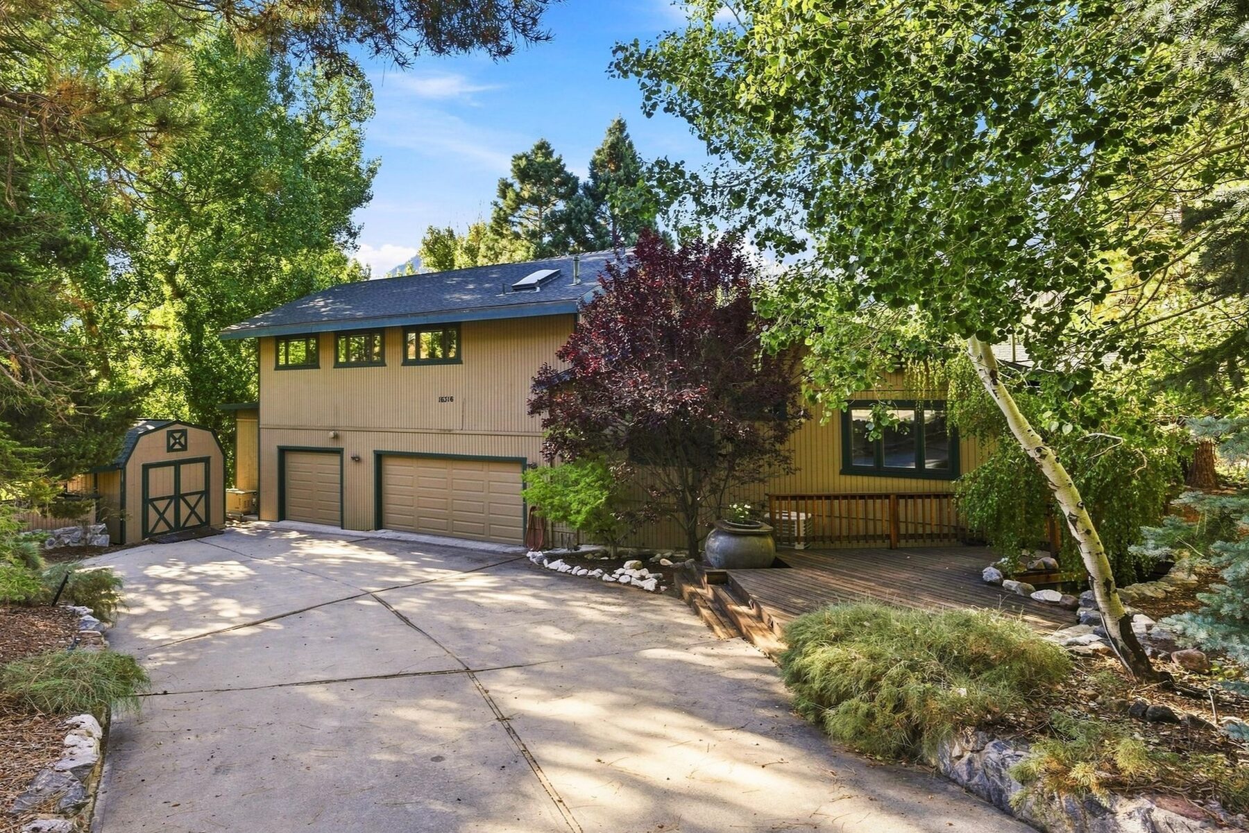 16316 Aleutian Drive — front exterior with two-car garage and wraparound deck