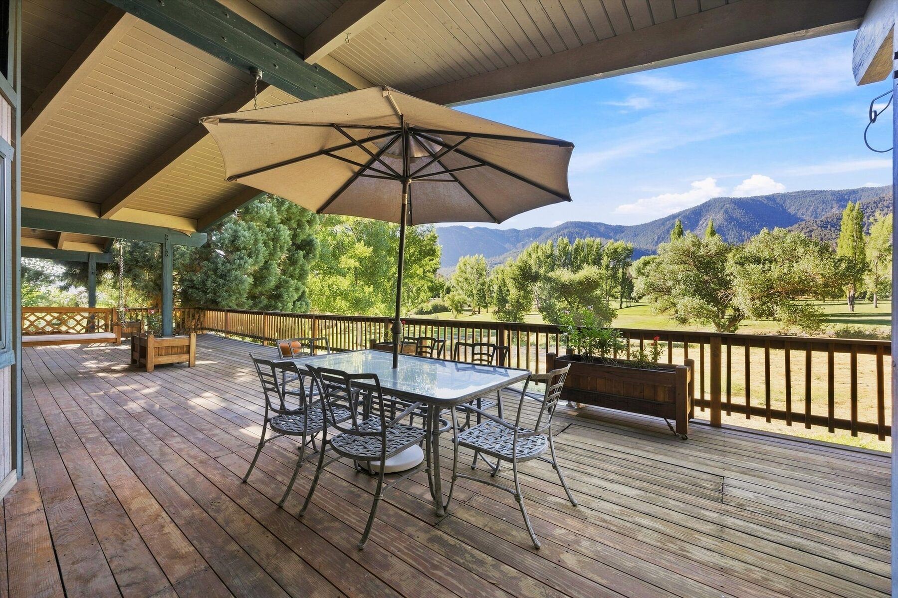 16316 Aleutian Drive — covered deck with dining table, umbrella, and golf course views
