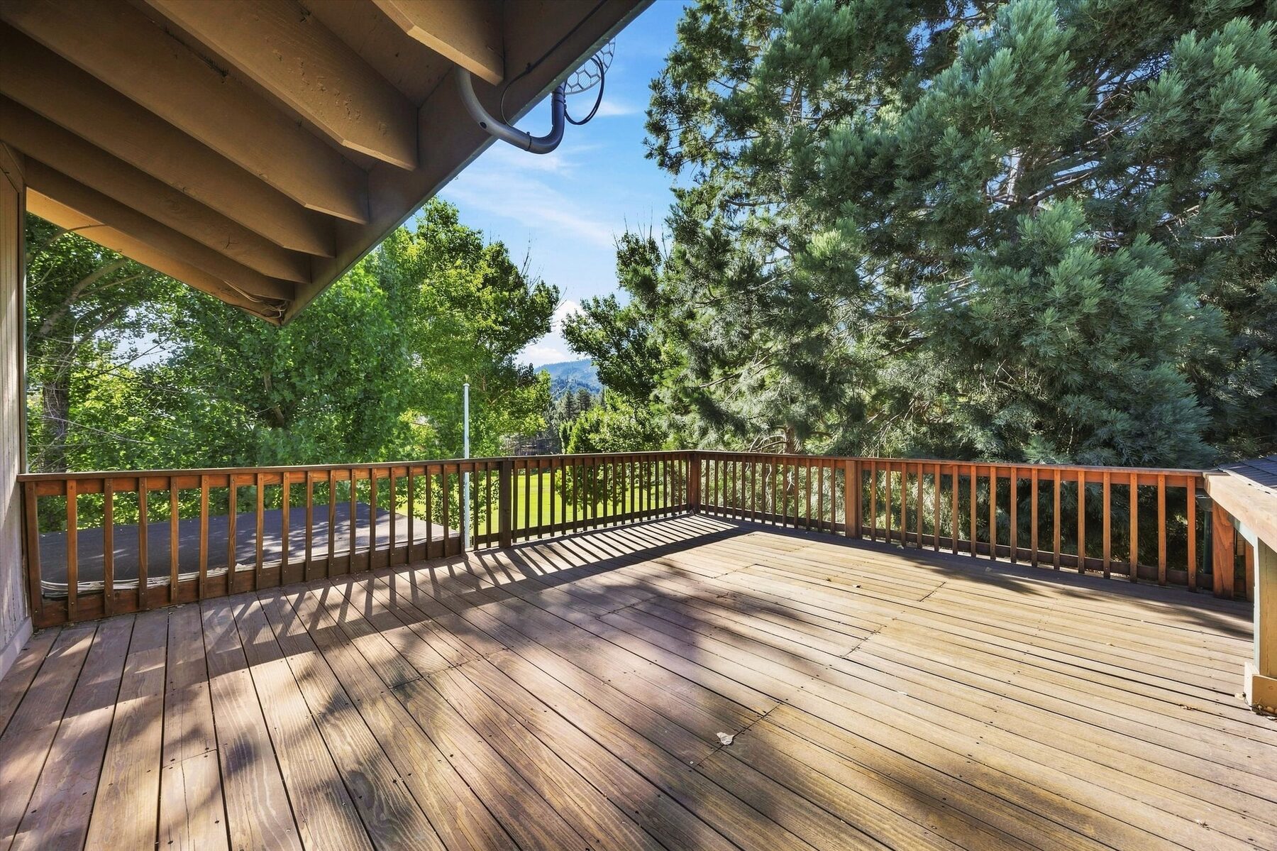 16316 Aleutian Drive — rear deck surrounded by mature trees and mountain views