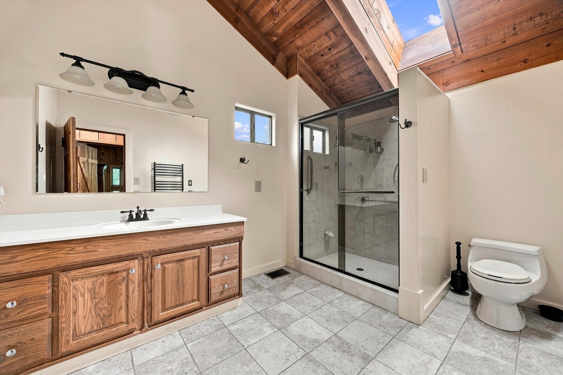 16316 Aleutian Drive — bathroom with double vanity, tile floor, and glass shower