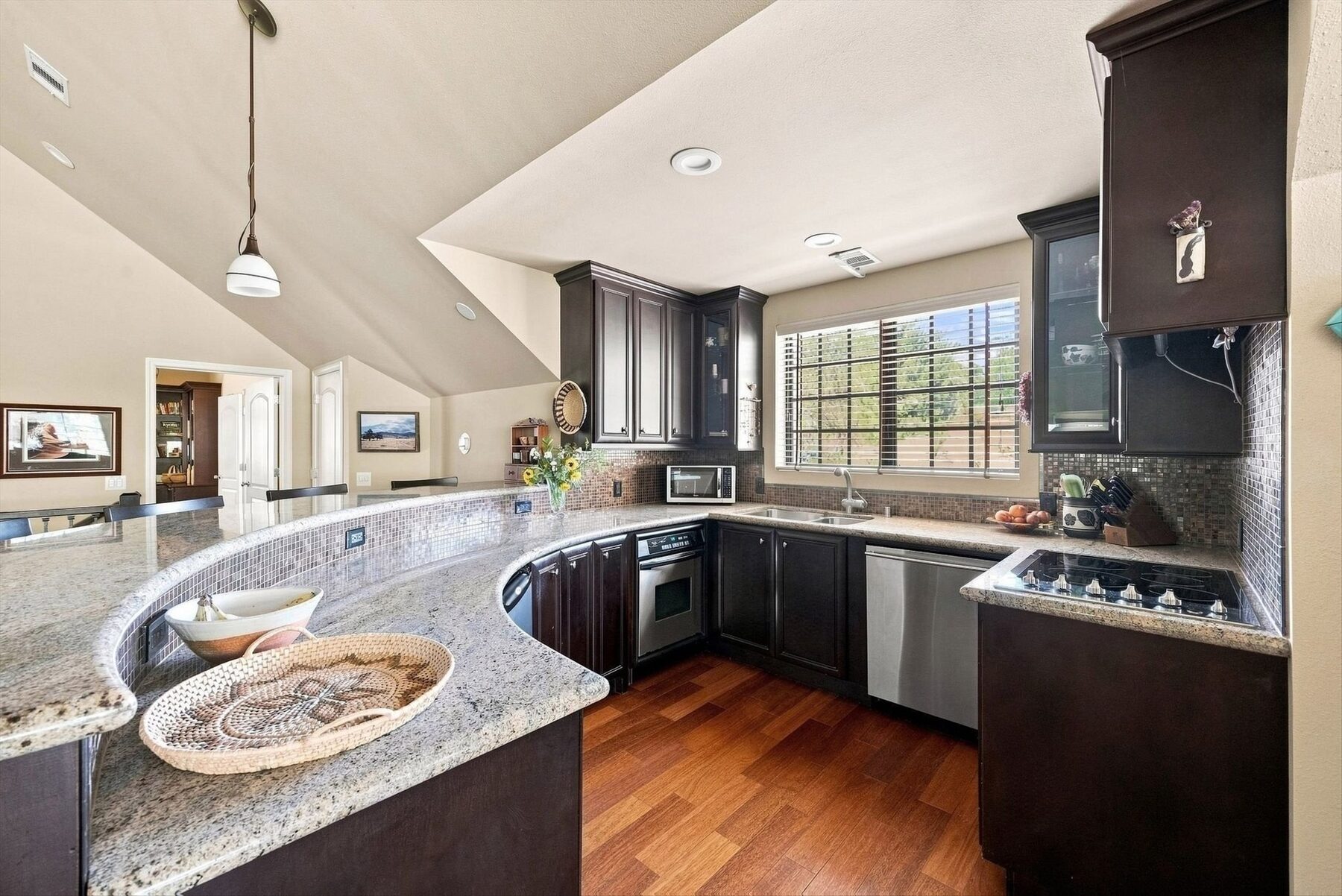 16330 Askin Drive — kitchen with curved granite counter, dark cabinetry, and stainless appliances