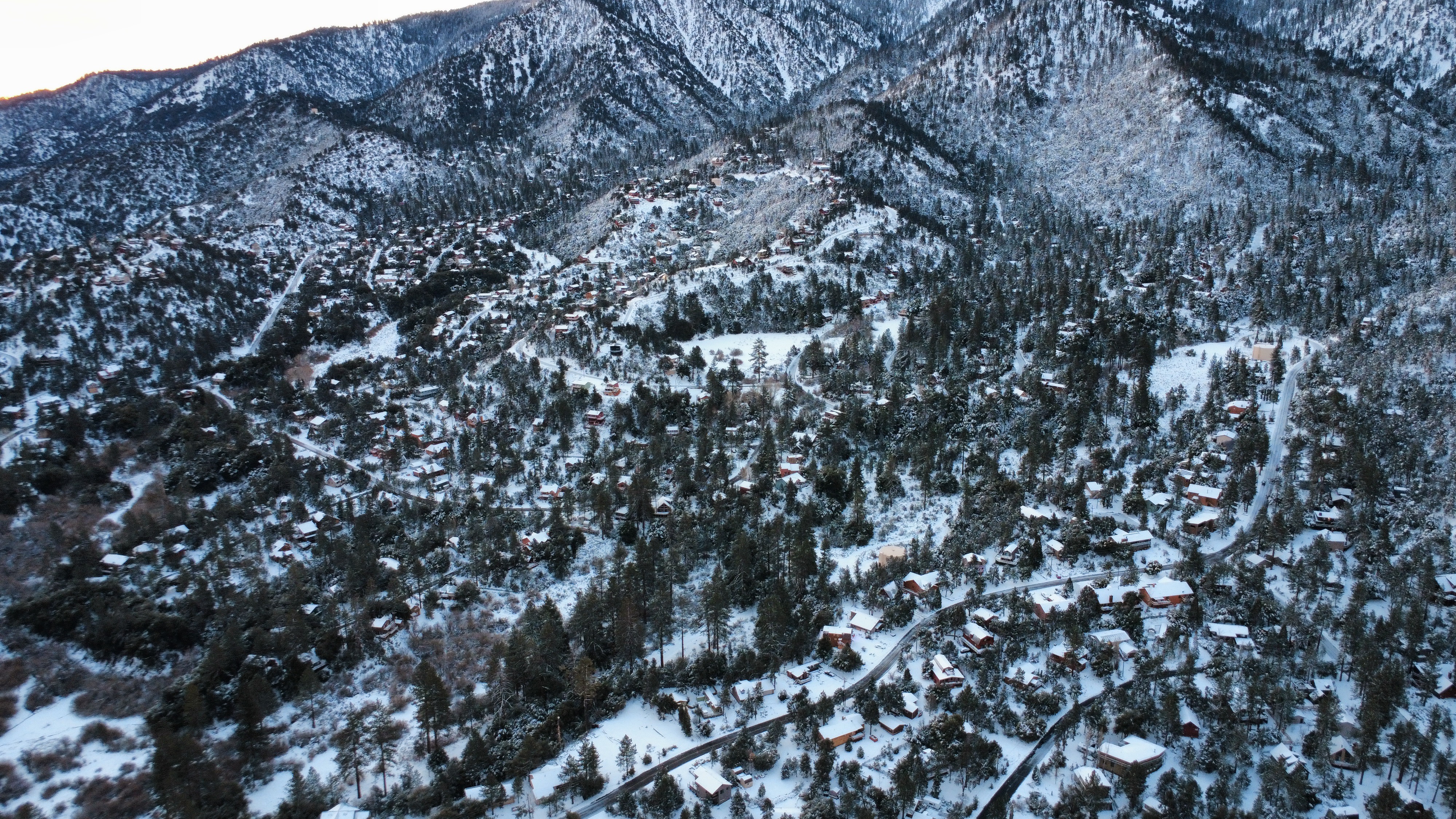 Pine Mountain Club winter dusk aerial view with snow-covered community and mountains