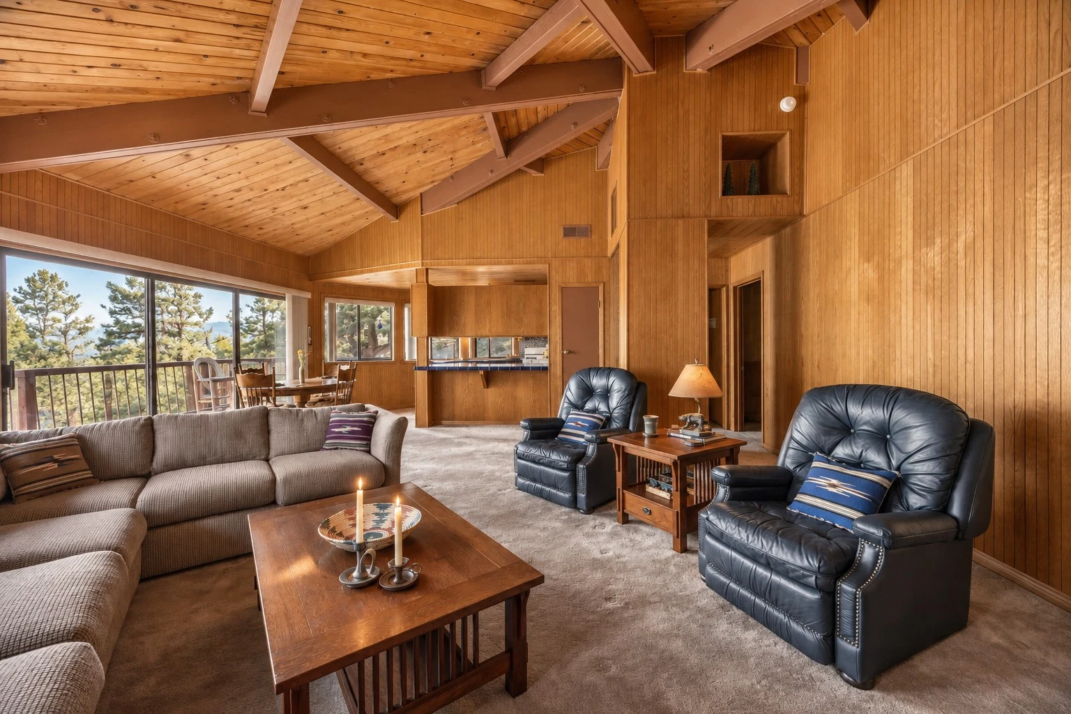 2104 Ironwood Drive — Living room seating beneath wood beams beside expansive windows