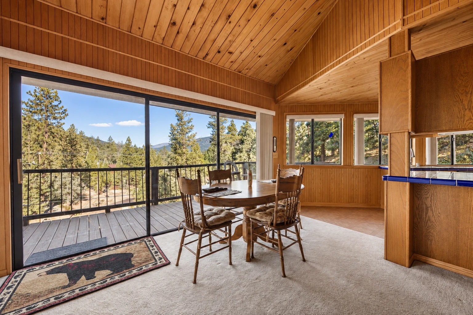 2104 Ironwood Drive — Wood-paneled dining area with mountain views and deck access