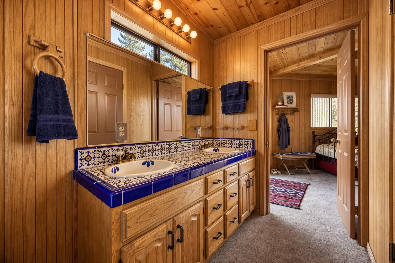 2104 Ironwood Drive — Double-sink vanity with wood cabinets and blue tile counters