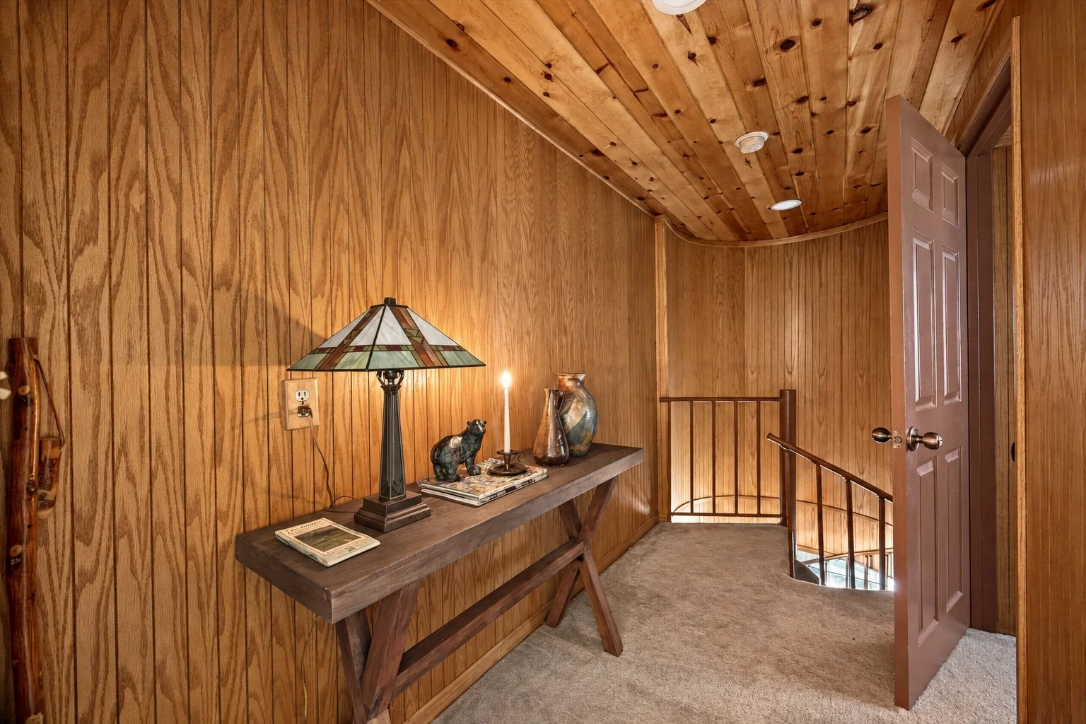 2104 Ironwood Drive — Wood-paneled hallway with access to the spiral staircase