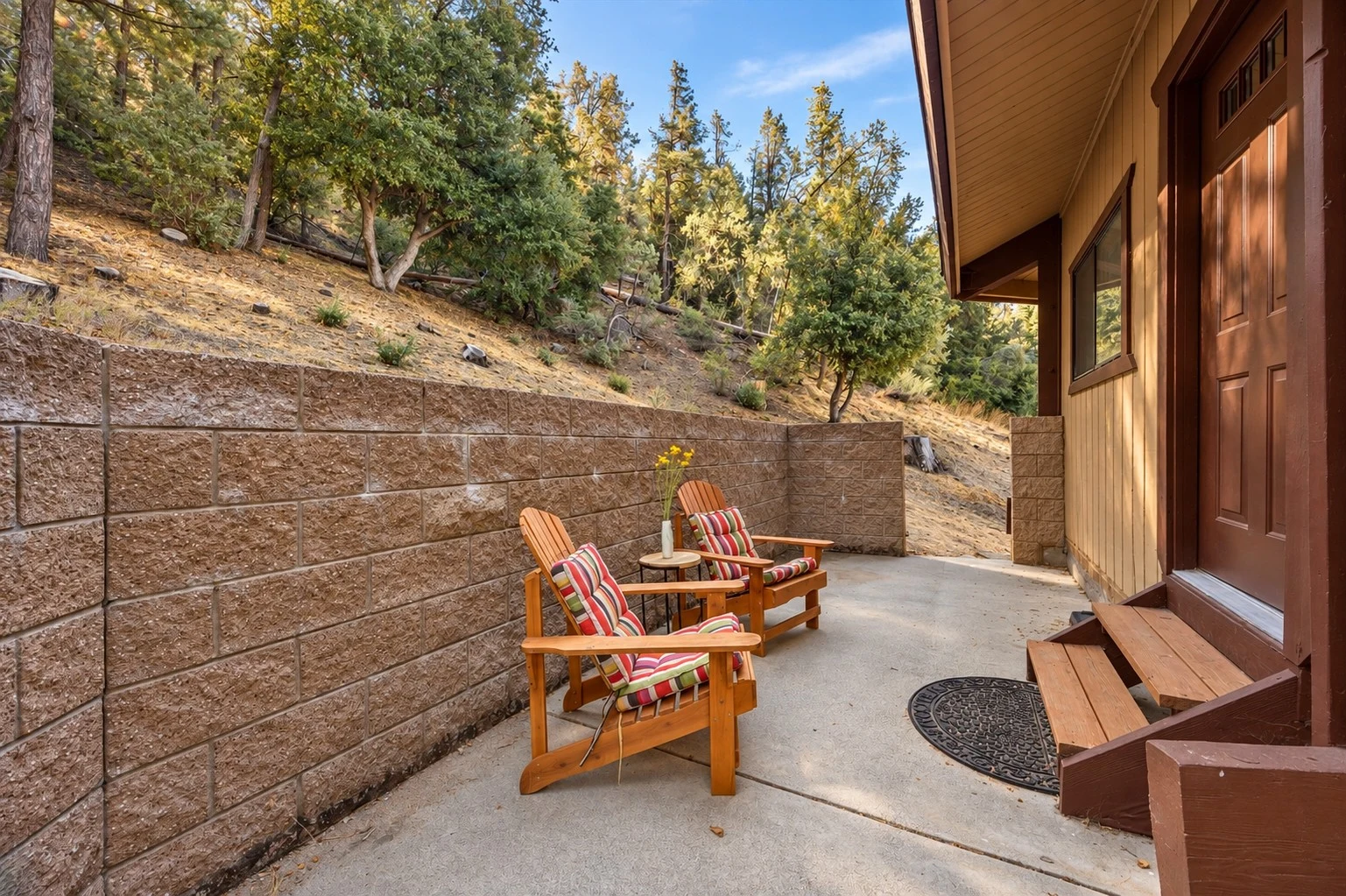 2104 Ironwood Drive — Rear patio seating alongside the home and wooded hillside