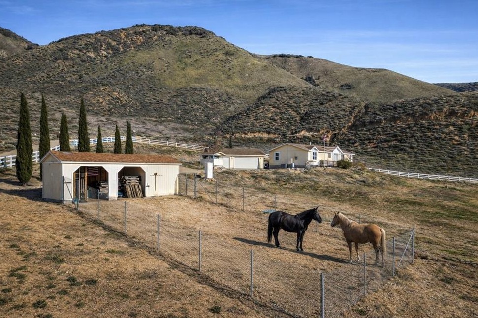 990 Mesa Valley Road — horses in paddock with barn, home, and Tehachapi Mountains in the background