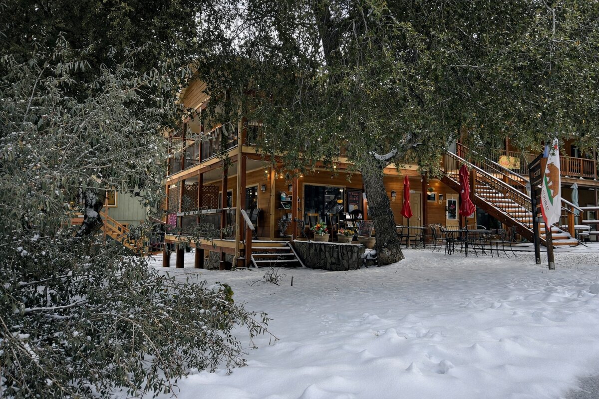 Village courtyard with string lights and California flag surrounded by fresh snow