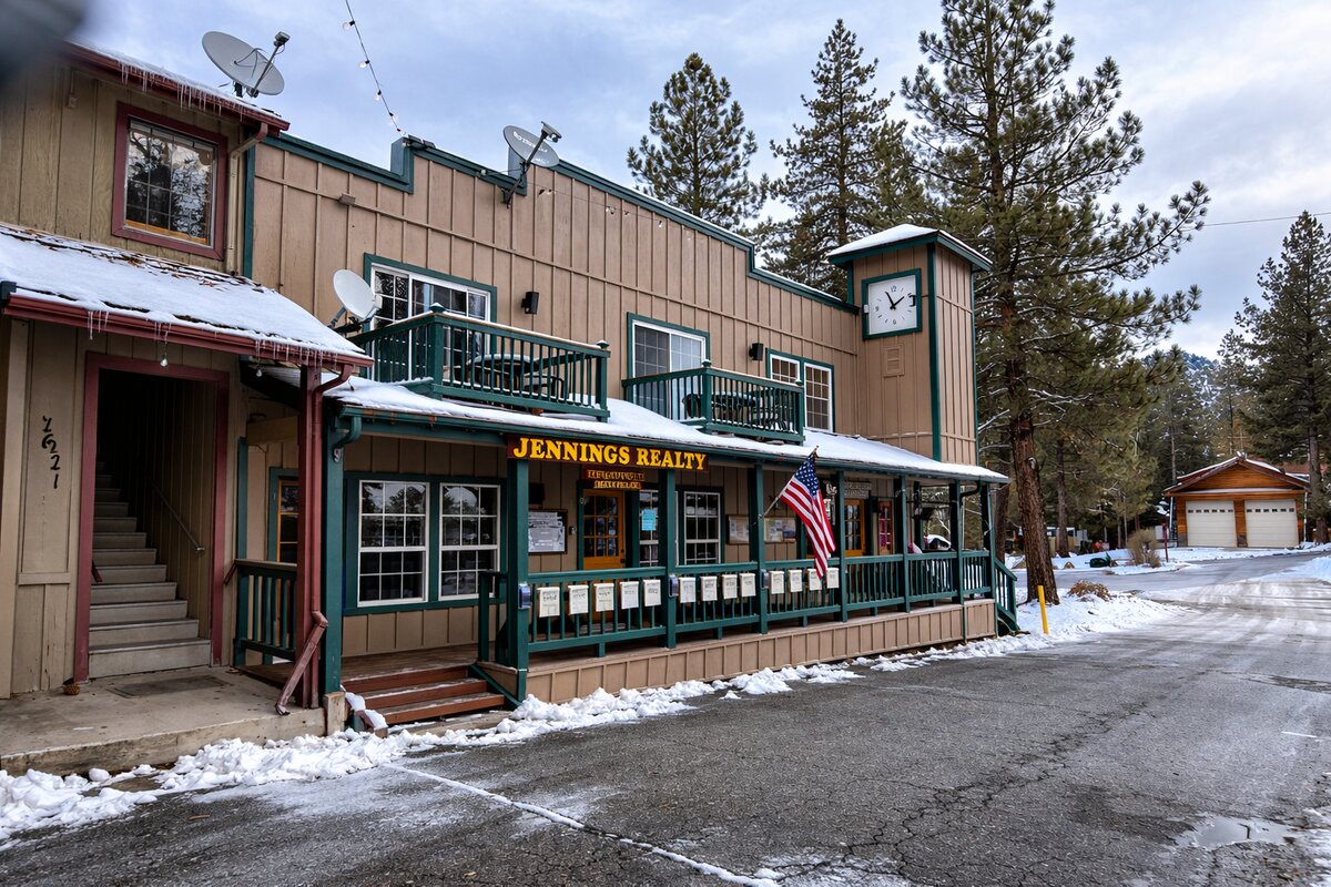 Jennings Realty storefront with American flag and snow in Pine Mountain Club
