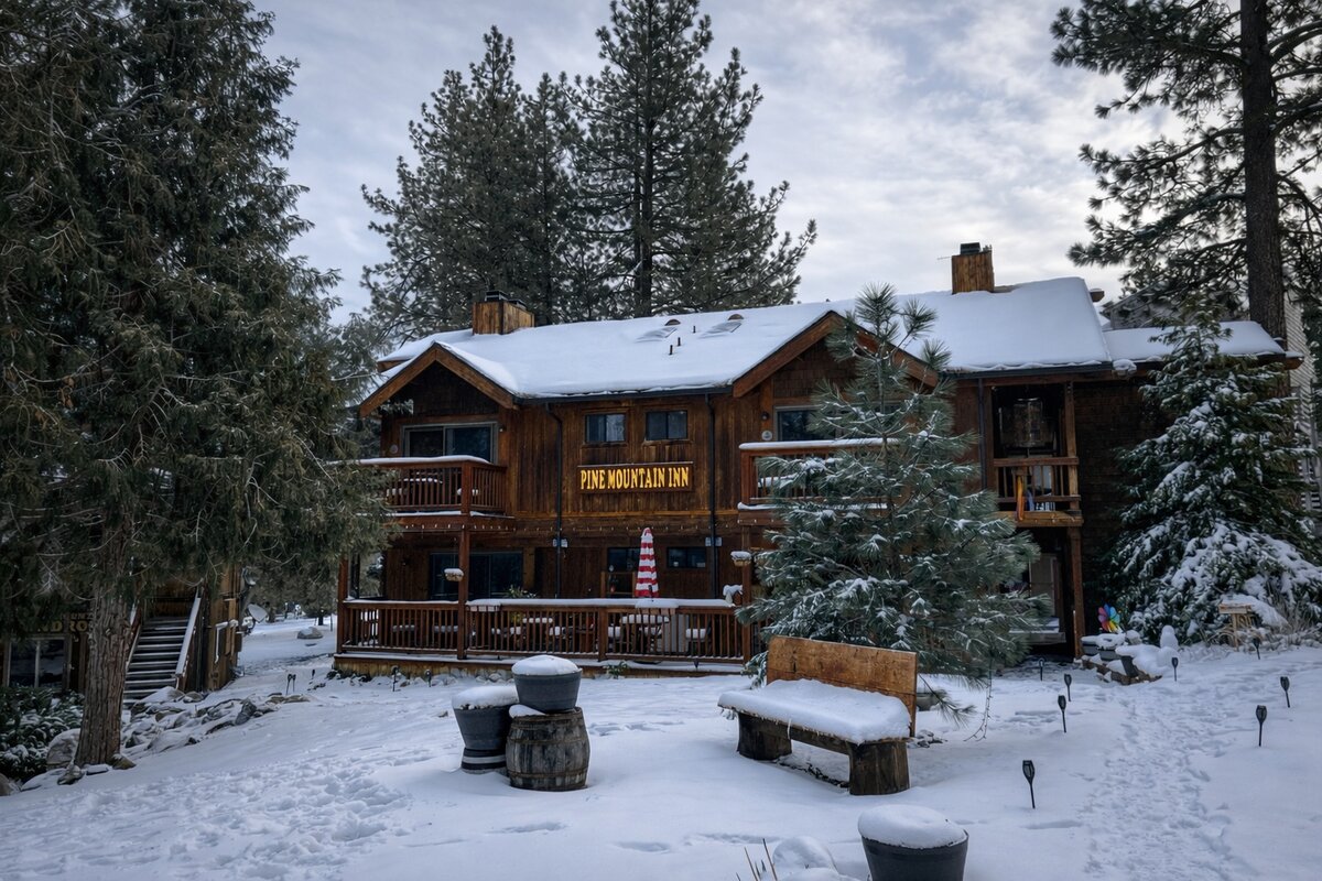 Pine Mountain Inn lodge covered in snow surrounded by tall pines